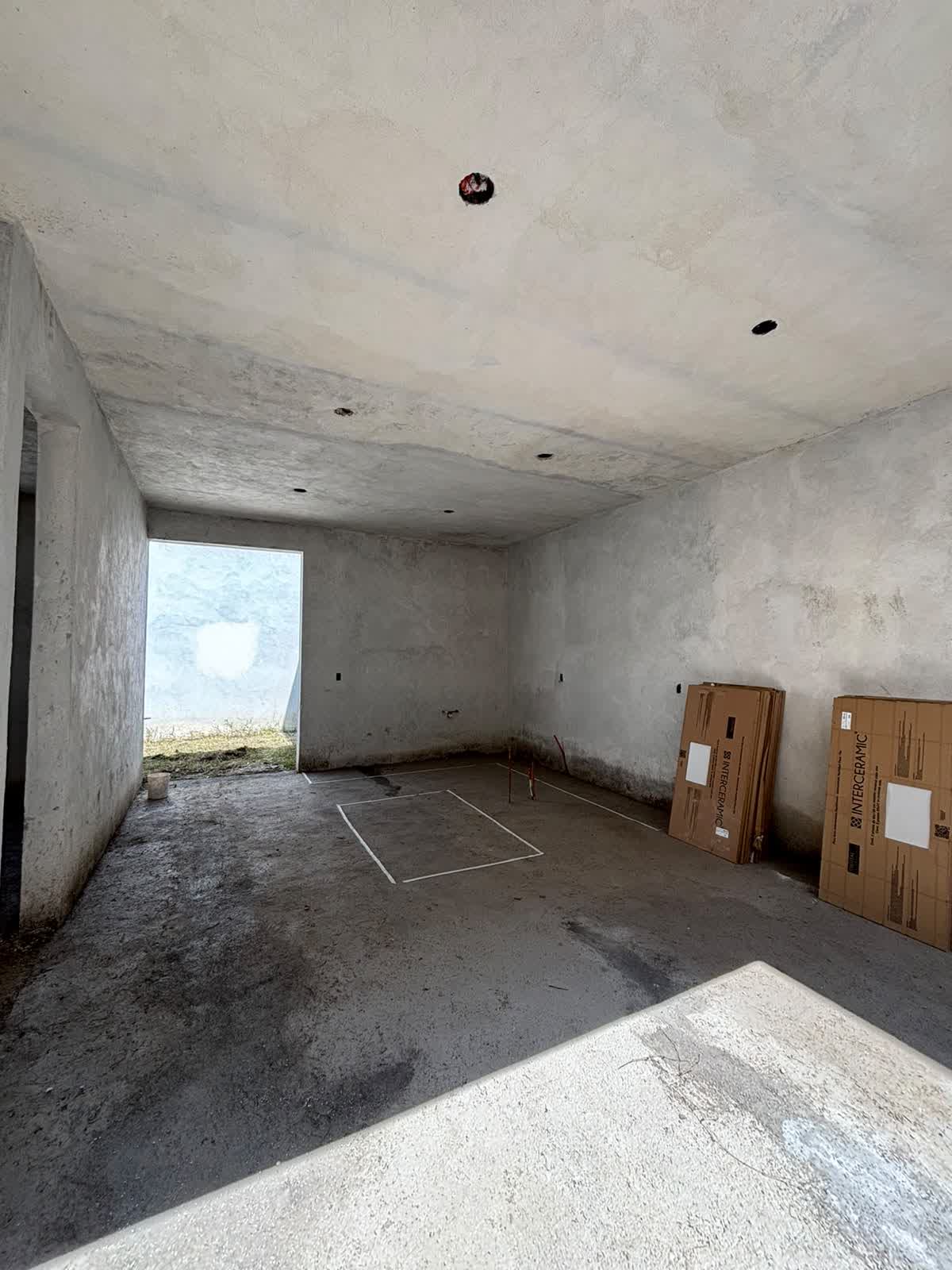 Interior en obra, muros de concreto y trazo de piso